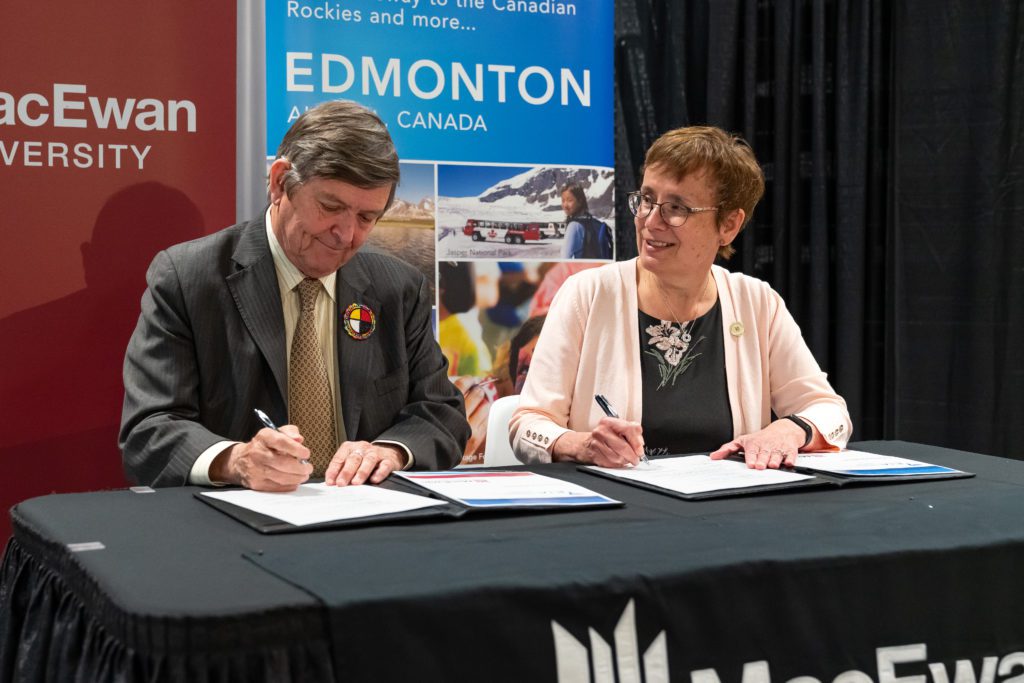 Tom Ruth et Dr. Annette Trimbee signent le nouvel accord entre l'Aéroport international d’Edmonton et l'université MacEwan.