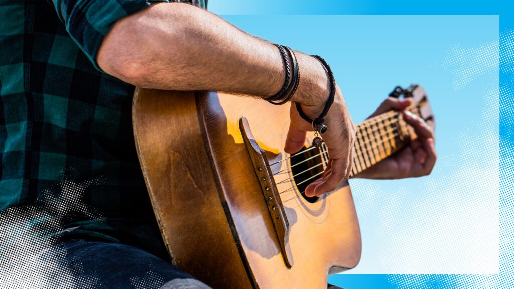A photo of a musician playing a guitar/Photo d’un musicien qui joue de la guitare