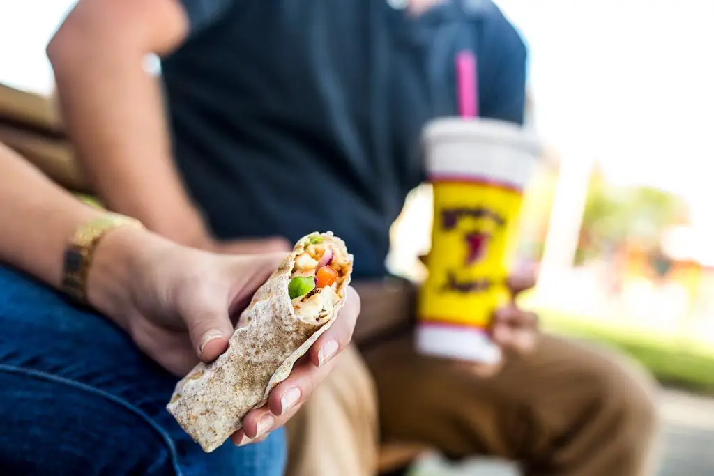 Photo of two customers enjoying a wrap and smoothie from Booster Juice