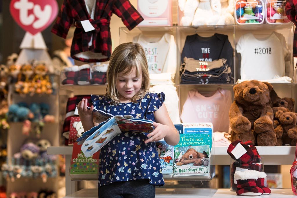 Photo of young girl reading a storybook inside the Indigo Spirit store
