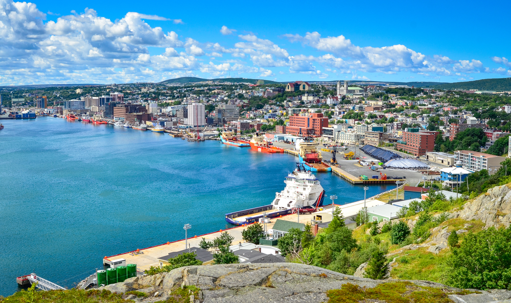 Panoramic views with bright blue summer day sky with puffy clouds over the harbor and city of St. John